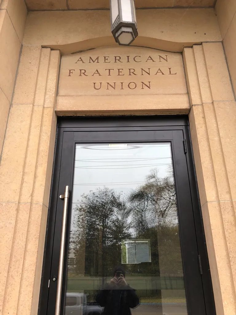 American Fraternal Union carved in stone above a new glass entry door