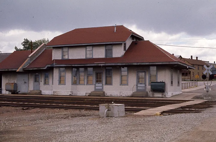 The red-roofed stucco depot seen from across the tracks