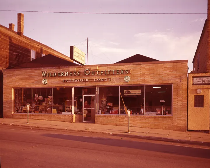 Wilderness Outfitters brick storefront in town with a Basswood Lodge sign