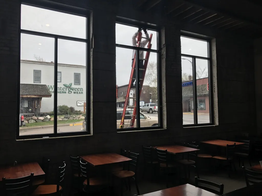 Tall new windows being installed, seen from the dining room