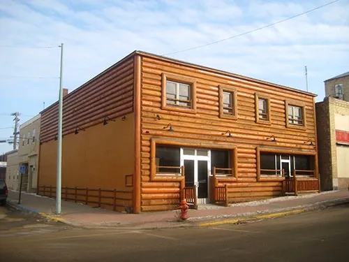The building covered in half-log siding