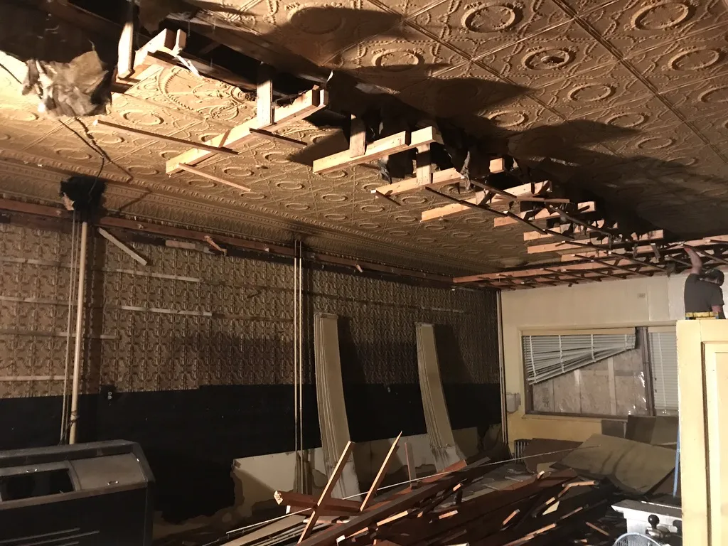The tin ceiling and tin walls revealed as old framing comes down