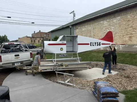 Crew guiding the floatplane off the trailer by its wings