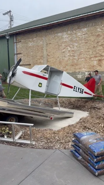 The white and red floatplane being slid off a trailer onto its pad