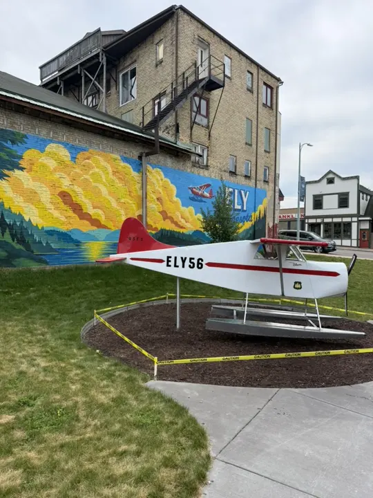 The floatplane on its floats in front of the colorful Ely, Minnesota mural