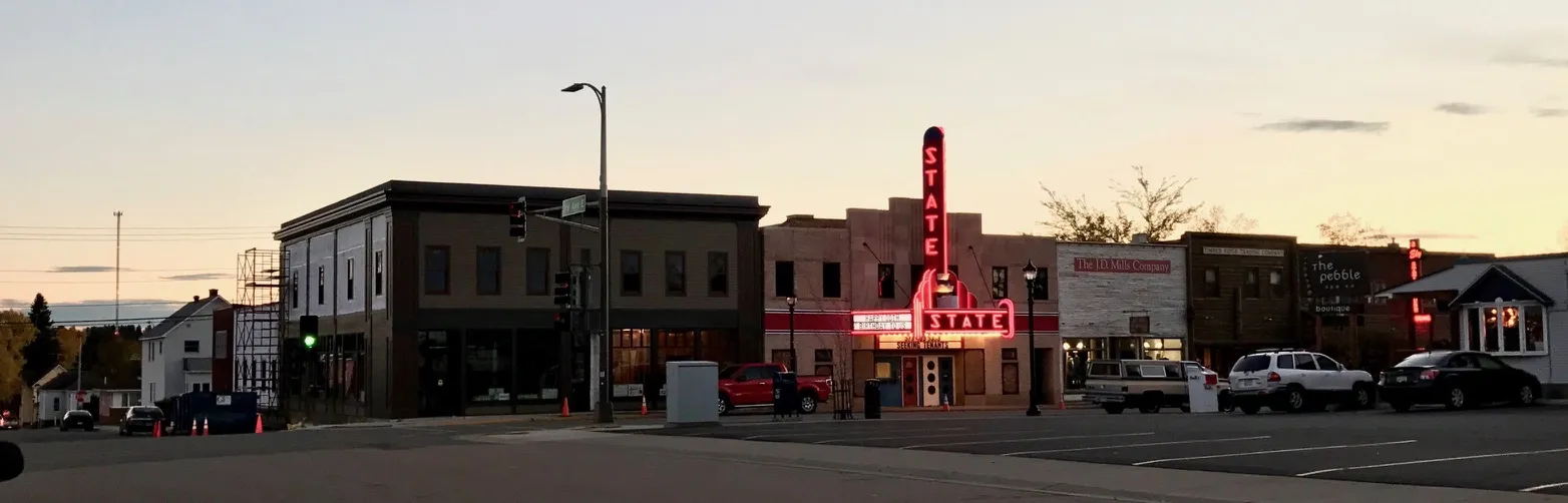 The Salerno Building and the glowing State Theater sign on Sheridan Street at dusk