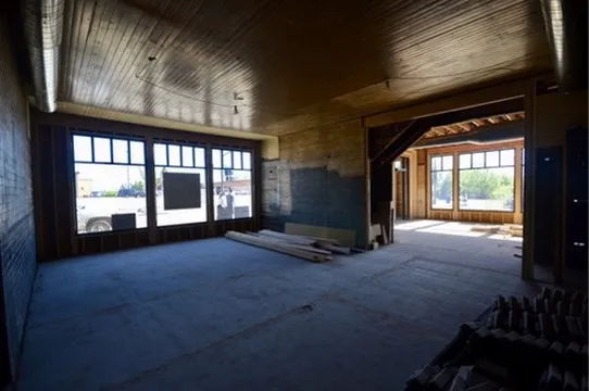 New corner storefront windows letting light into the gutted interior