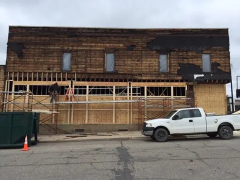The old facade stripped to its boards with new sheathing going on below