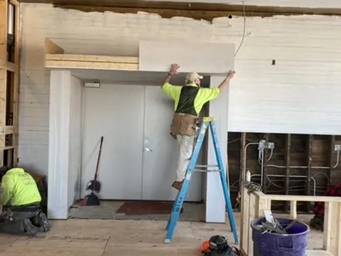 A carpenter installing trim above a doorway