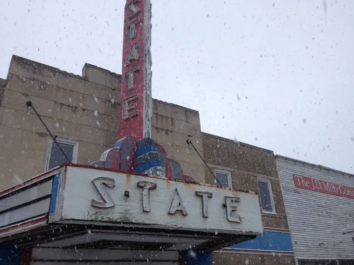 The weathered STATE marquee in falling snow