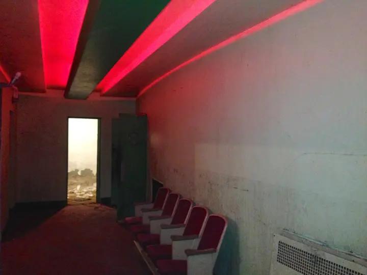 A side hallway lit by red and green neon cove lighting