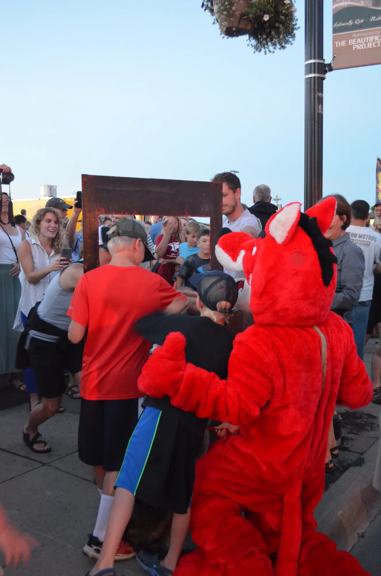 The mascot and kids crowding around the switch box