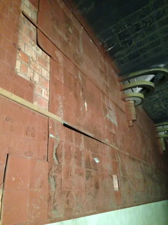 Loose acoustic wall tiles with brick showing through and Art Deco sconces